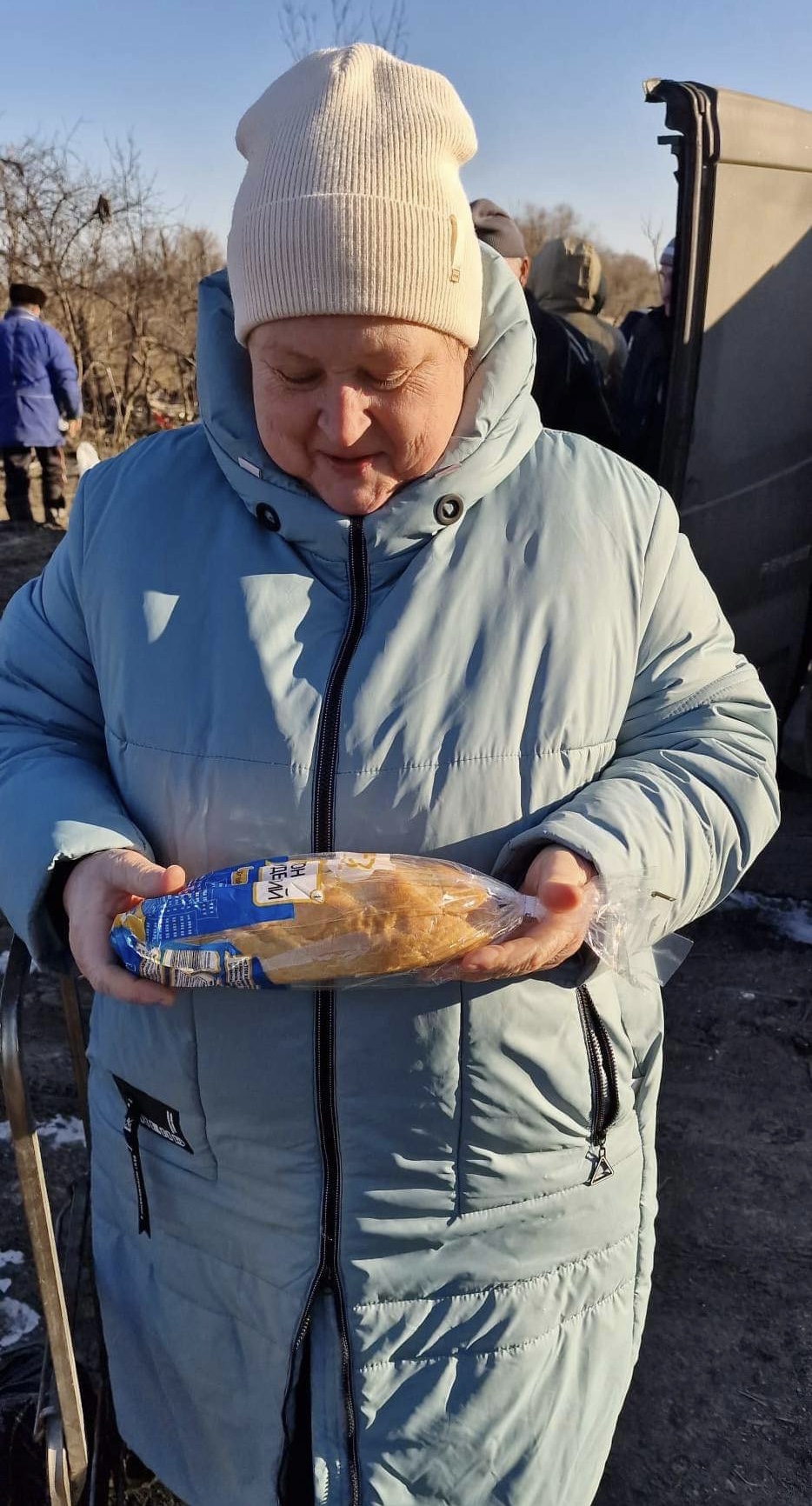 一位女士高興地拿到一條麵包